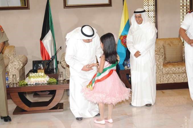 الشيخ خالد الجراح مصافحا احدى المكرمات ﻿