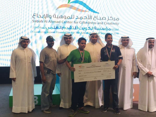 اعضاء يتسلمون شيك الجائزة بعد فوزهم بالمركز الاول ﻿