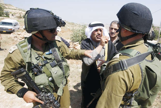 فلسطيني يزجر شرطة الاحتلال خلال هدمها منازل لفلسطينيين قرب الخليل بالضفة امس	رويترز﻿