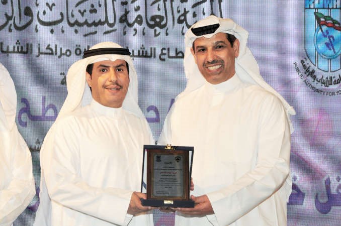 الزميل عبدالهادي العجمي يتسلم تكريم الانباء من دحمود فليطح