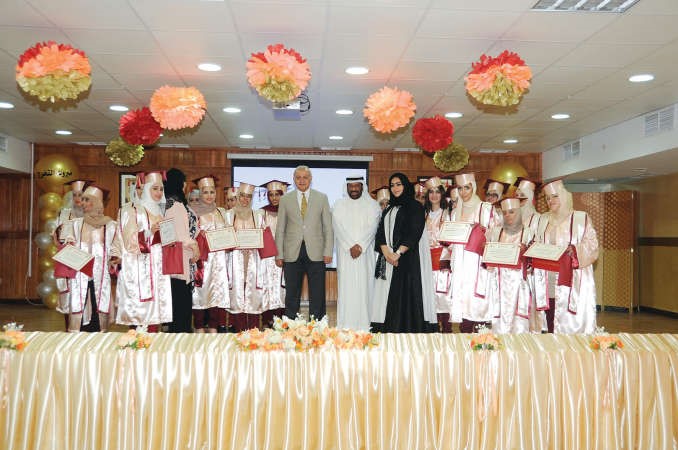دبدر العيسى ومديرة المدرسة نعيمة العبيد وحمود بن ثاني يتوسطون عددا من الطالبات الخريجات