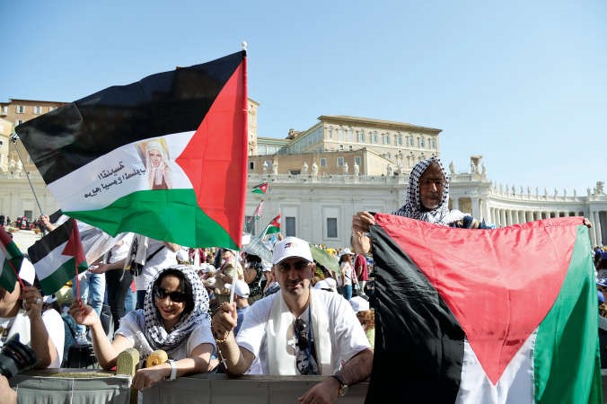 فلسطينيون يرفعون العلم الوطني فيساحة سانت بيتراحتفالا بتطويب راهبتين فلسطينيتين في الفاتيكان امس	افپ ﻿