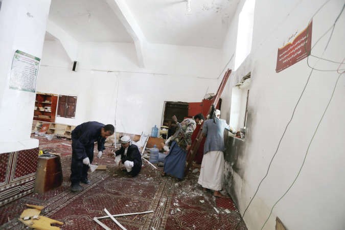 خبير في الطب الشرعي ويمنيون يبحثون عن ادلة في موقع انفجار قنبلة في مسجد في صنعاء							رويترز﻿