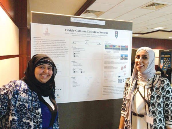 الطالبتان اصايل المطوع وجمانة الجابر بجانب عرضهن البحثي﻿