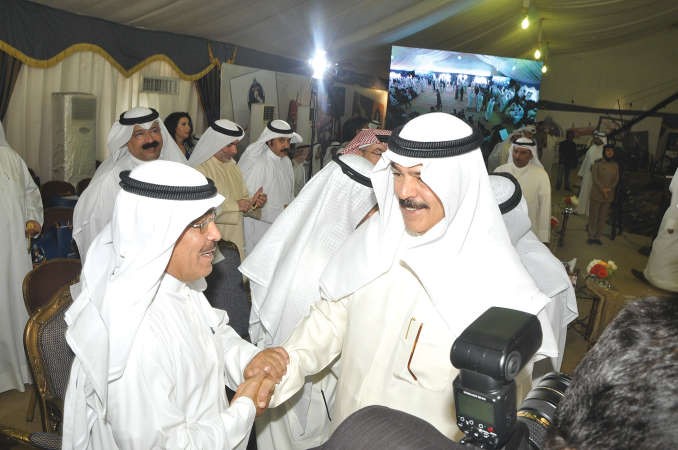 نائب رئيس مجلس الوزراء ووزير الداخلية الشيخ محمد الخالد مصافحا نائب رئيس التحرير الزميل عدنان الراشد 