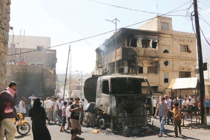  يمنيون يعاينون اثار تفجير شاحنة نفط عقب اشتباكات بين المقاومة والمتمردين الحوثيين في تعز امس الاول اپ