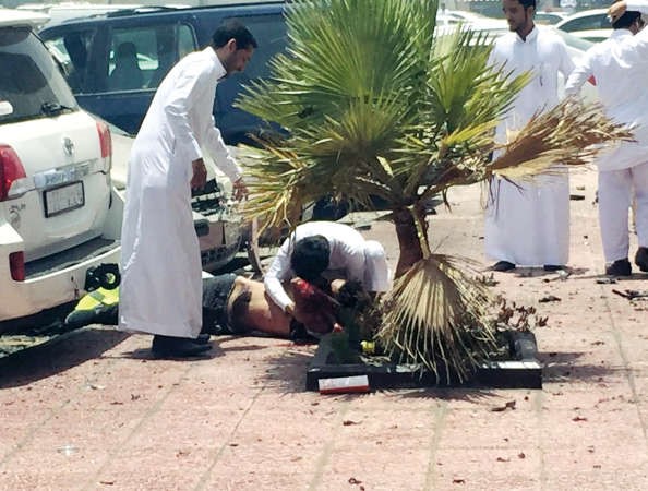 سعوديون يعاينون جثة احدى الضحايا عقب انفجار السيارة الملغومة قرب مسجد العنود في الدمام 	رويترز﻿