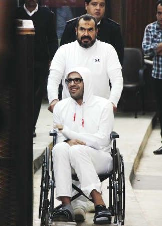 صورة ارشيفية لمحمد على كرسيه المتحرك ويدفعه والده صلاح سلطان اثناء المحاكمة في مارس الماضياپ﻿