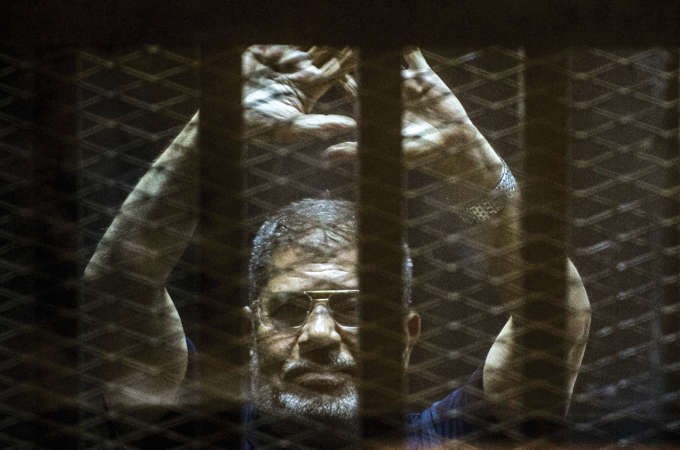 الرئيس المصري السابق محمد مرسي يرفع يده اثناء المحاكمة امس