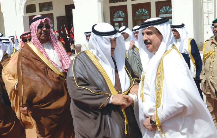 العاهل البحريني مصافحا سمو الشيخ ناصر المحمد ويبدو الشيخ جابر الخالد قبيل مغادرتهما البحرين 