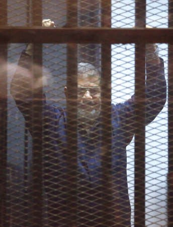  والرئيس المصري المعزول محمد مرسي رافعا يديه عقب النطق بالحكم اپ