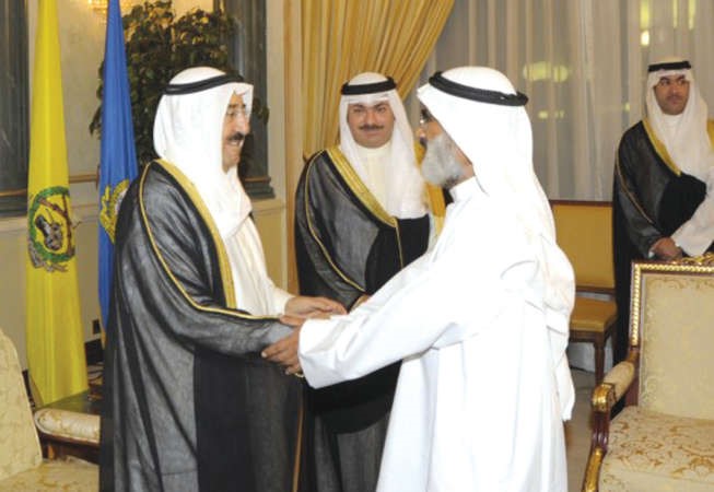 صاحب السمو الامير الشيخ صباح الاحمد مصافحا د عجيل النشمي بحضور الشيخ خالد العبدالله
