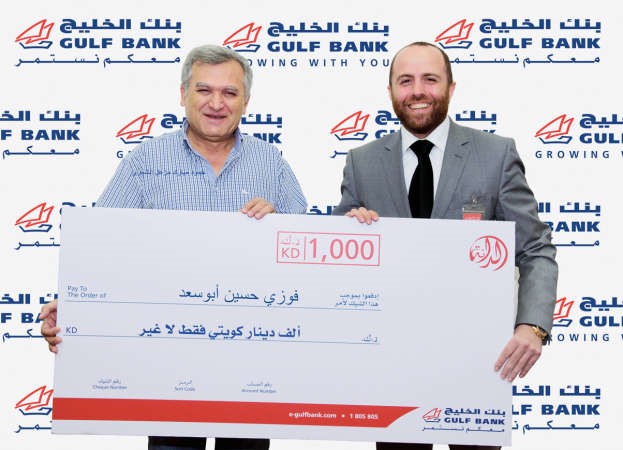 مدير فرع بنك الخليج في الفروانية علي البرجاوي يسلم فوزي ابوسعد الجائزة ﻿