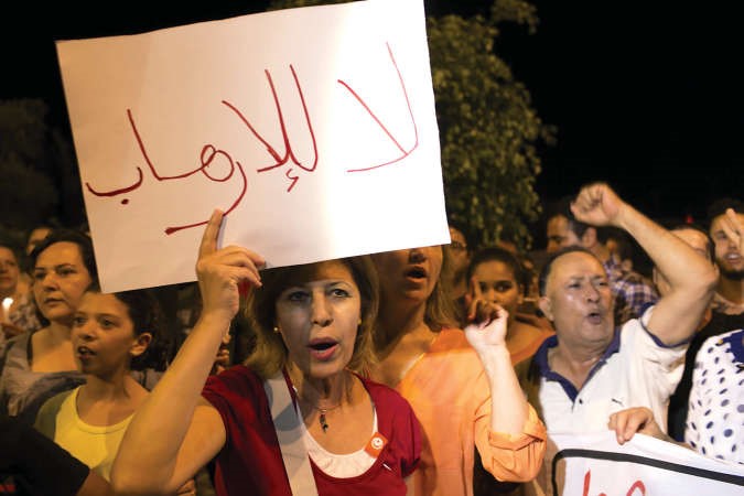 تونسيون يرفعون لافتات مناهضة للارهاب خلال مسيرة ليلية في مدينة سوسة امس الاول رويترز 