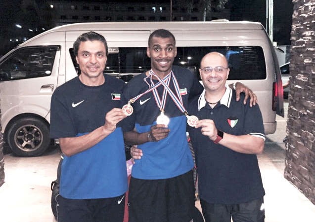 اللاعب يعقوب اليوحة حاملا ميداليته مع الطاقم الفني 