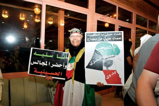 مواطنة تحمل لافتة كتب عليها انا سنية واحضر المجالس الحسينية﻿
