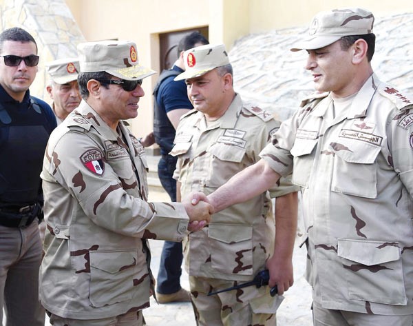 الرئيس المصري عبد الفتاح السيسي بالزي العسكري مصافحا احد عناصر القوات المسلحة في سيناء امساپ
