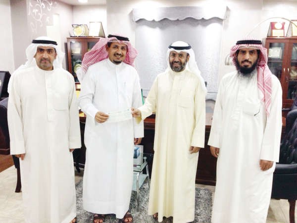 محمد العجمي يتسلم الشيك من مسعود العنزي بحضور حمود الكندري وفهد الدوسري 