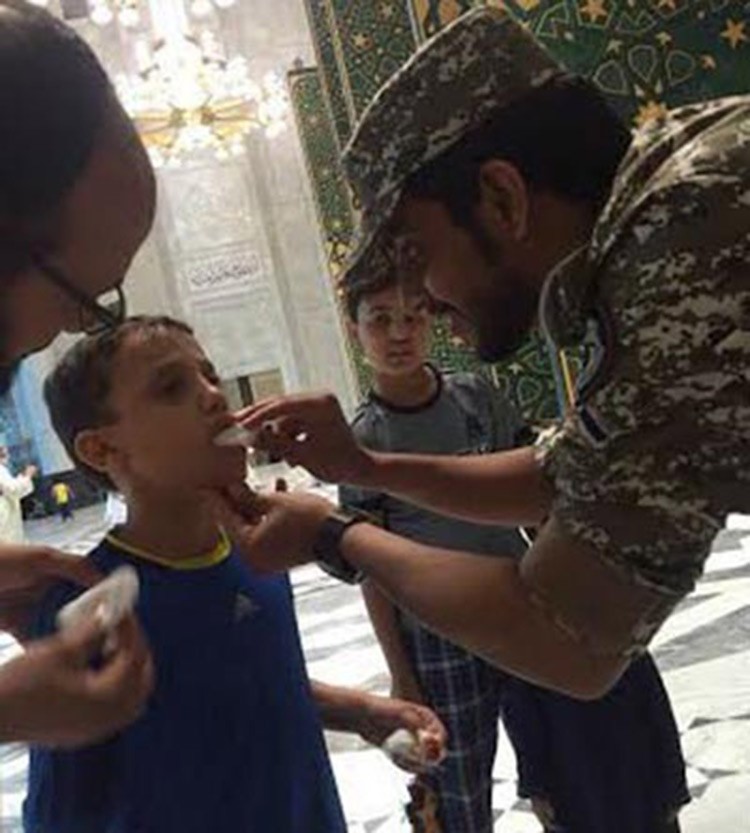 صورة: رجل أمن سعودي يضمد طفلاً مصاباً بالحرم المكي