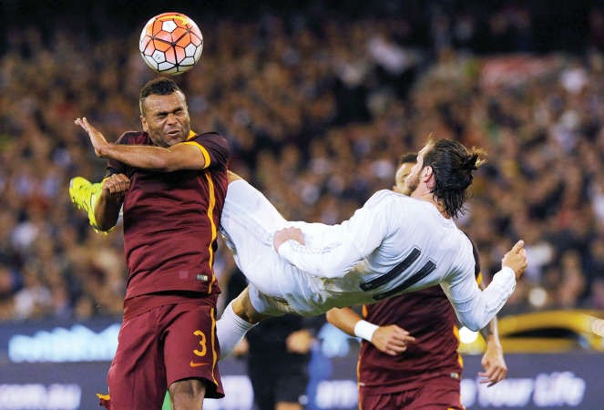لاعب الريال غاريث بيل يطير للكرة بمضايقة اشلي كول مدافع روما افپ
