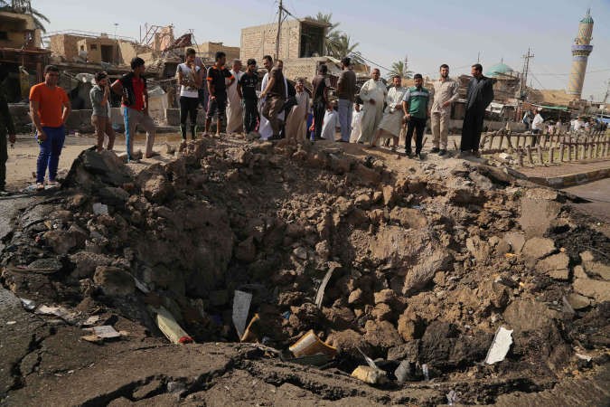 عراقيون يعاينون اثار التفجير الانتحاري في خان بني سعد بمحافظة ديالى امس الاول					اپ﻿