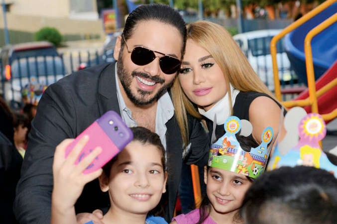 رامي مع زوجته في جمعيته الخيرية عياش الطفولة