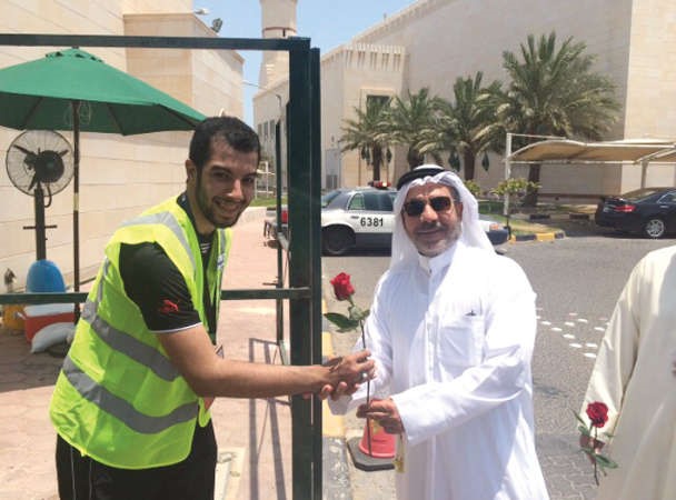 اللواء متقاعد مصطفى خان يتسلم وردة من احد المتطوعين امام المساجد﻿