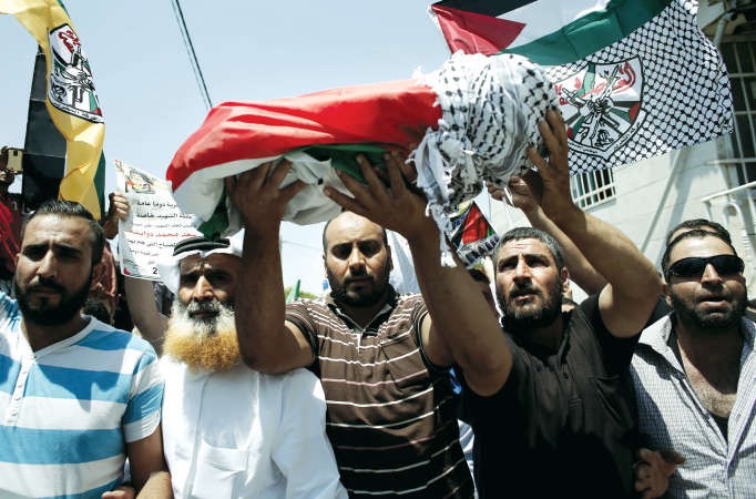 فلسطينيون يحملون جثمان الرضيع القتيل علي دوابشة خلال جنازته امس	افپ ﻿