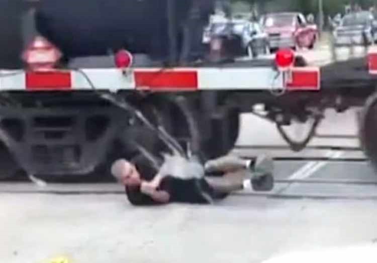بالفيديو.. رجل يخاطر بحياته ويعبر من تحت قطار متحرك