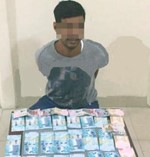 الوافد الاسيوي وامامه مبلغ الرشوة الذي قدمه الى رجل الامن