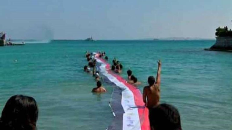  العلم المصري خلال نشره على الممر الملاحي الجديد لقناة السويس امس اليوم السابع
