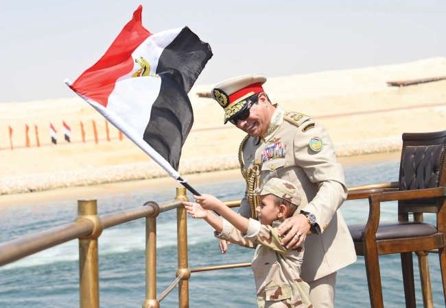 الرئيس السيسي برفقة الطفل عمر صلاح المصاب بالسرطان يلوح بالعلم احتفالا على متن المحروسة
