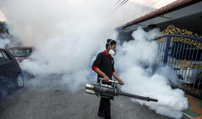 عامل بالخدمات الصحية في ماليزيا يقوم برش مبيدات حشرية لمكافحة البعوض في كوالالمبور