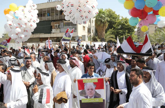 مزارعون عراقيون يرفعون صور رئيس الوزراء حيدر العباديفي بغداد امس تعبيرا عن تاييدهم لخططه الاصلاحية	 اپ﻿