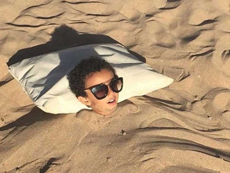 صورة: أسماء المنور تدفن ابنها في الرمال