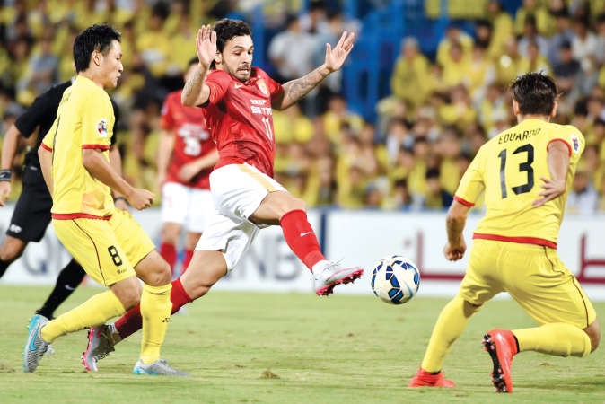 لاعب غوانغجو ريكارودو يحاول المرور من مدافعي كاشيوا افپ﻿