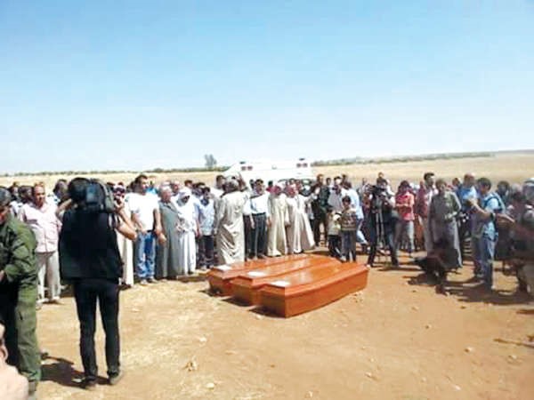 جثامين الطفل الغريق ايلان وشقيقه ووالدته قبل ان يواروا الثرى في كوباني امس وفي الاطار صورة لايلان افپ - رويترز 