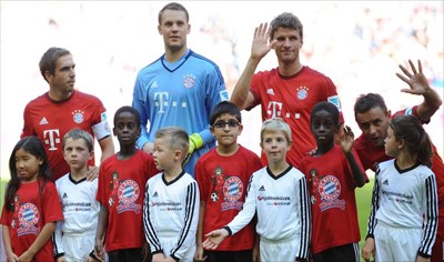 لاعبو بايرن اصطحبوا طفلين أحدهما من اللاجئين لدى دخولهم أرضية ملعب أليانز أرينا
