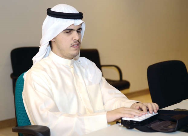 ناصر المرزوق مستخدما جهازا تعويضيا للمكفوفين برايل سينس 