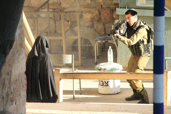 جندي اسرائيلي يرفع البندقية في وجه الطالبة الفلسطينية هديل الهشلمون قبل ان يرديها قتيلة في الخليل امس الاول رويترز