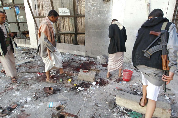 مجمموعة من المتمردين الحوثيين يعاينون موقع التفجير امام المسجد في صنعاء امسافپ