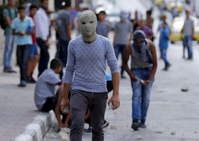 فلسطيني يستعد لرشق الحجارة على قوات الاحتلال في الضفة الغربية رويترز