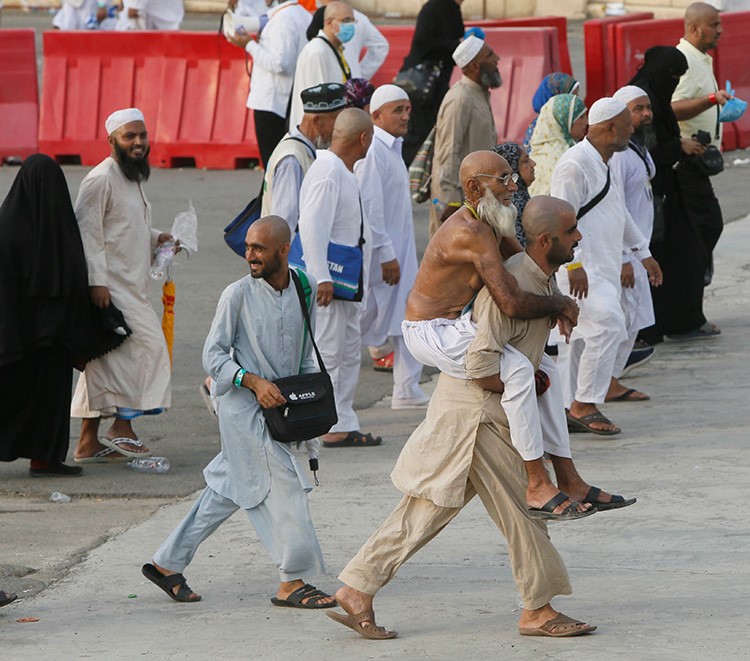 صور الحاج الذي حمل والده على ظهره لمسافة كيلو