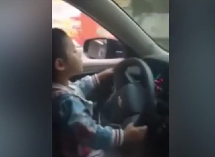 بالفيديو.. صيني يعلم طفله قيادة السيارة في شارع مزدحم