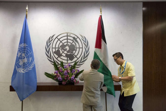عمال يضعون العلم الفلسطيني في الامم المتحدة قبيل لقاء محمود عباس وبان كي مونرويترز﻿
