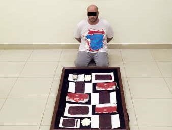 المتهم وامامه المواد المخدرة المضبوطة ﻿