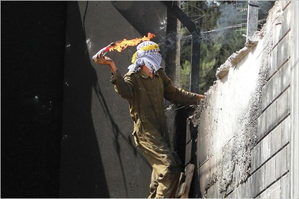 متظاهر فلسطيني يقذف قنبلة مولوتوف على قاعدة اسرائيلية خلف الجدار العازل في ابو دبس	 افپ