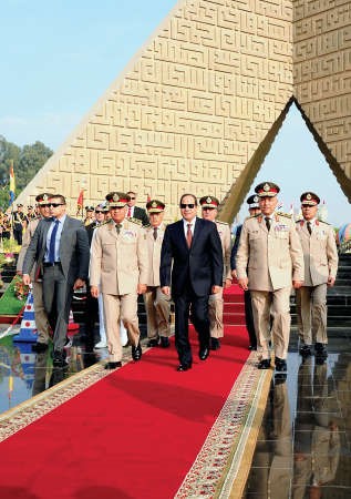 عبدالفتاح السيسي يتوسط وزير الدفاع ورئيس الاركان خلال زيارة قبر الرئيس السابق انور السادات والنصب التذكاري للجندي المجهول افپ