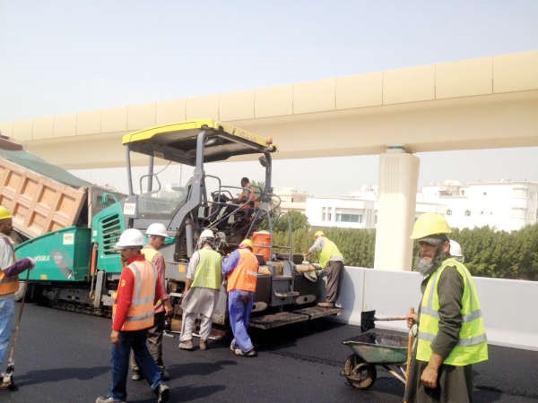 اليات الاشغال ومهندسو وعمال طريق الجهراء خلال رصف احدى مراحل المشروع﻿