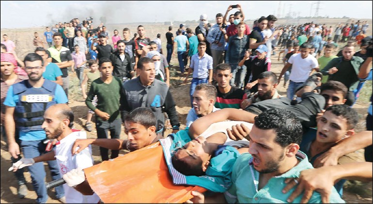 فلسطينيون يسعفون احد الجرحى الذين سقطوا خلال الاعتداء الاسرائيلي عليهم في غزة امس	 رويترز